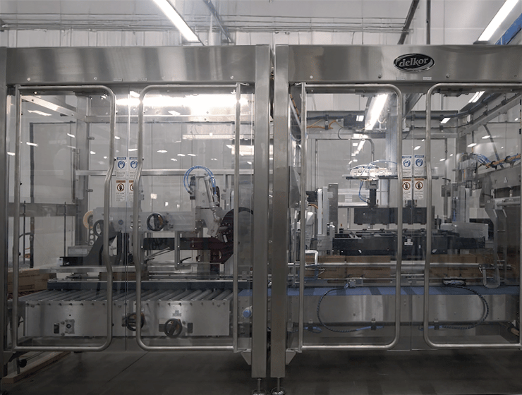 A photo of Delkor's CS Series Sealer and Performance Series Case Packer side by side A photo of Delkor's CS Series Sealer and Performance Series Case Packer side by side