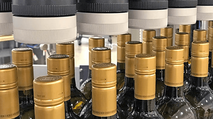 A close-up images of glass bottles on a Delkor case packing line