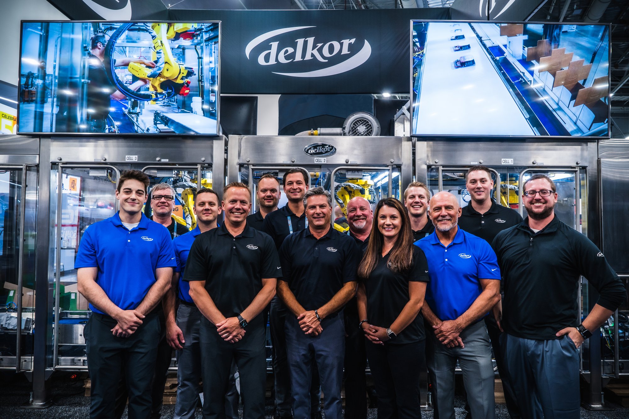 Delkor team members in front of a Delkor machine
