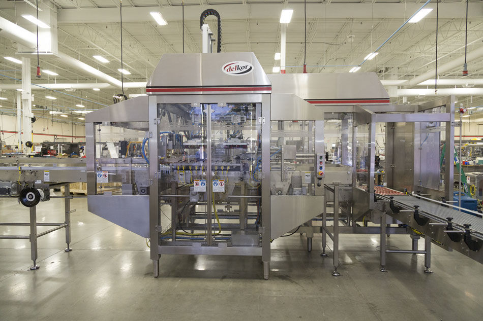 Flexible case packer with a more compact footprint Flexible case packer with a more compact footprint